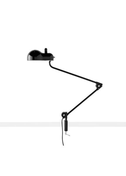Topo lamp on a white background. The lamp has a metal shell with slits and a lampshade that corresponds to the classic E27 bulb casing. It has jointed metal arms for extending or retracting and is available in various finishes.