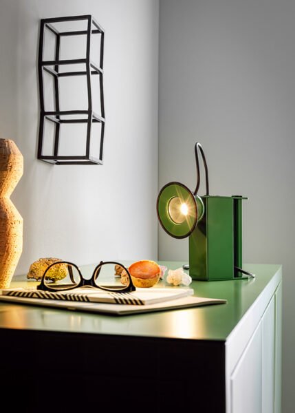 Small table light with a metal body a luminous eye that resembles a miner’s lamp.