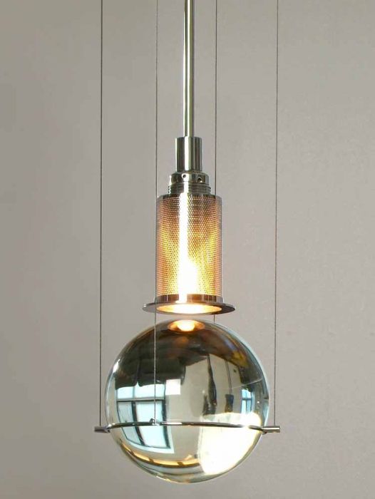 Tecnolumen_hl3s81_1 | rewire Hanging pendant light with a clear glass sphere and a perforated metal shade above it, emitting a warm glow
