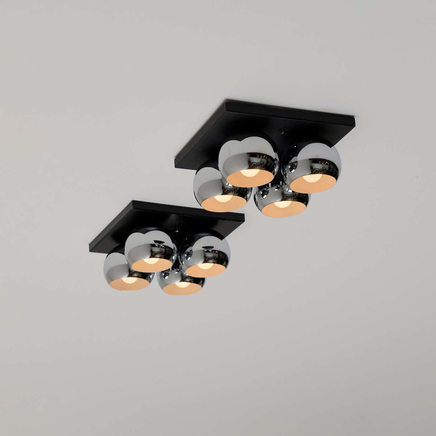 pair of mirrored ceiling lights with black mounting plate