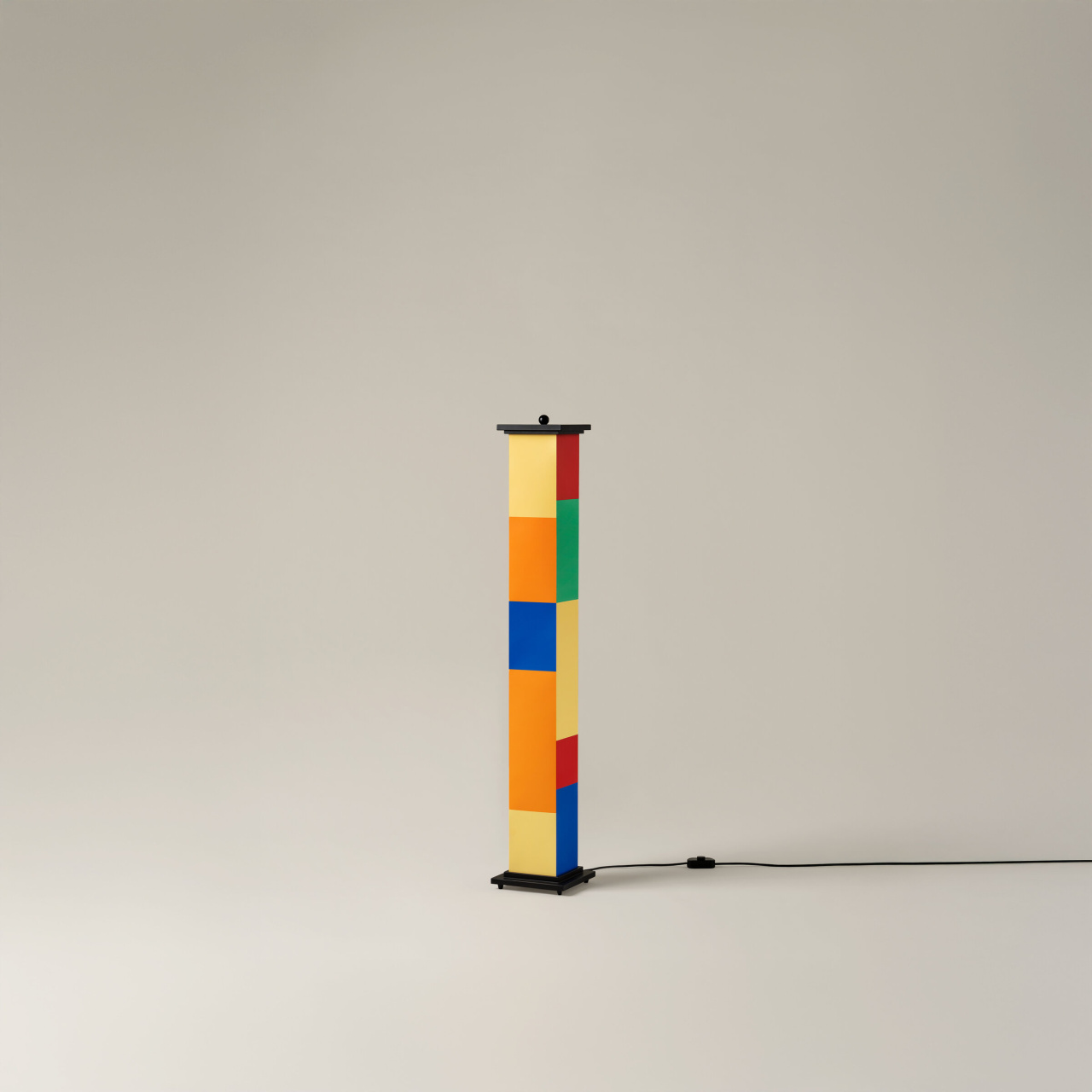 La-bella-durmiente-menor-enric-badrinas-2024-17-off-r25-x2400-1280x1280 | rewire Tall column sculpture made of multicolored rectangular blocks on a black base, with a small top piece and a power cord trailing along the floor.