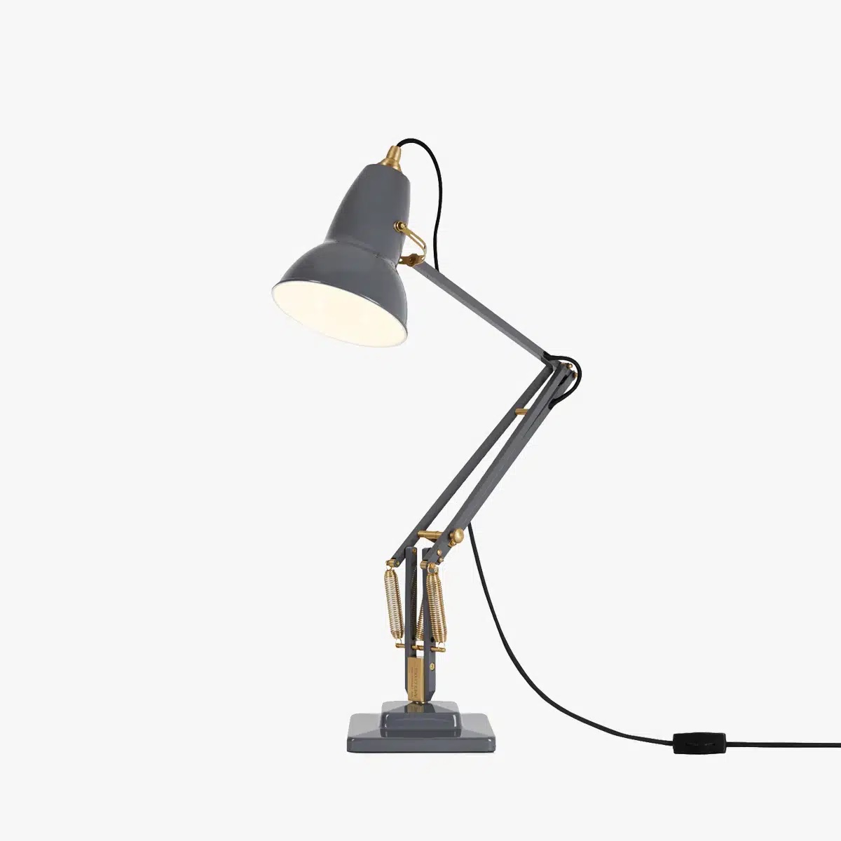 Original-1227-brass-desk-lamp-elephant-grey-3jpg | rewire Gray adjustable desk lamp with brass accents and exposed springs, plugged in and lit at the desk arm.