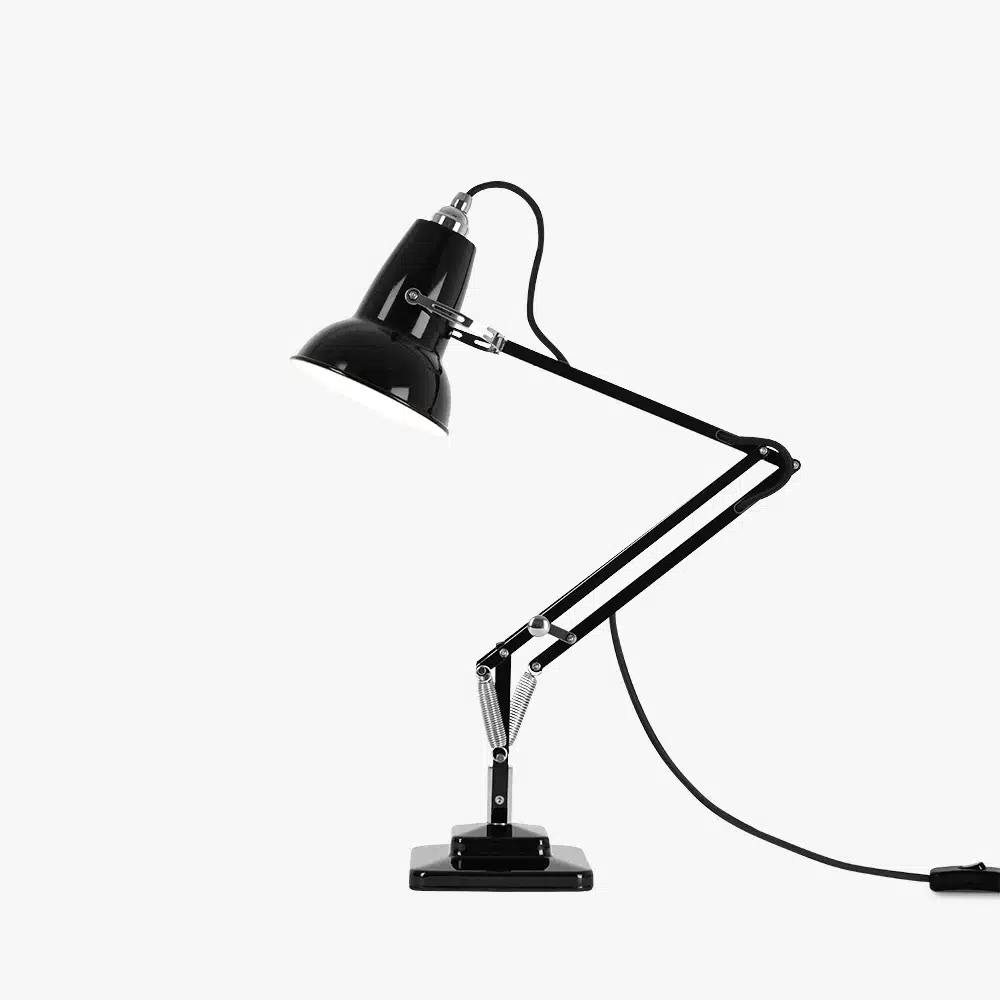 Original-1227-mini-desk-lamp-jet-black-2-offjpg | rewire Black adjustable desk lamp with articulated arms and a metal spring joint, plugged in on a white background, viewed at side angle.