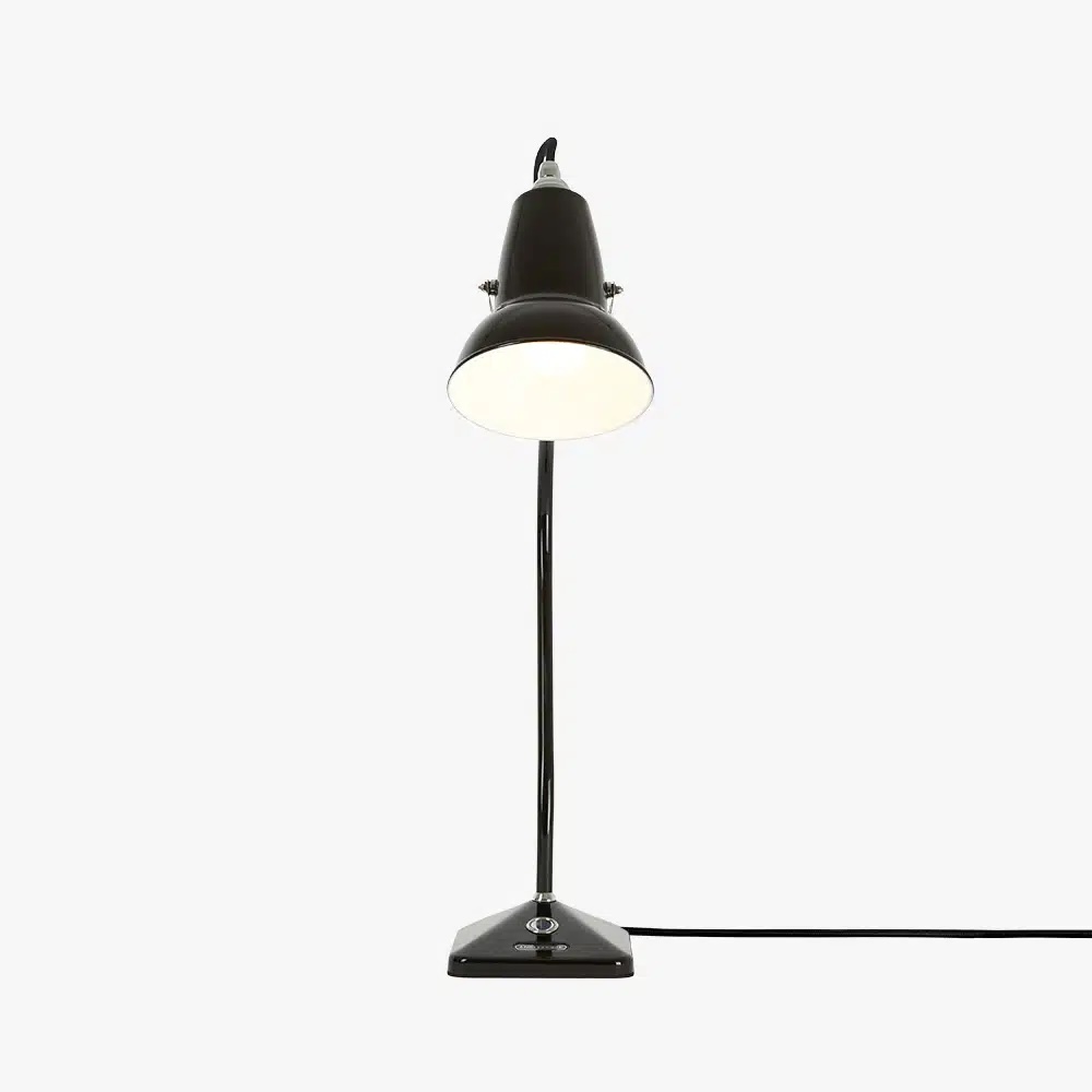Original-1227-table-lamp-jet-black-3_1jpg | rewire Black metal desk lamp with a lit white lampshade on a slim stand and a wired base.
