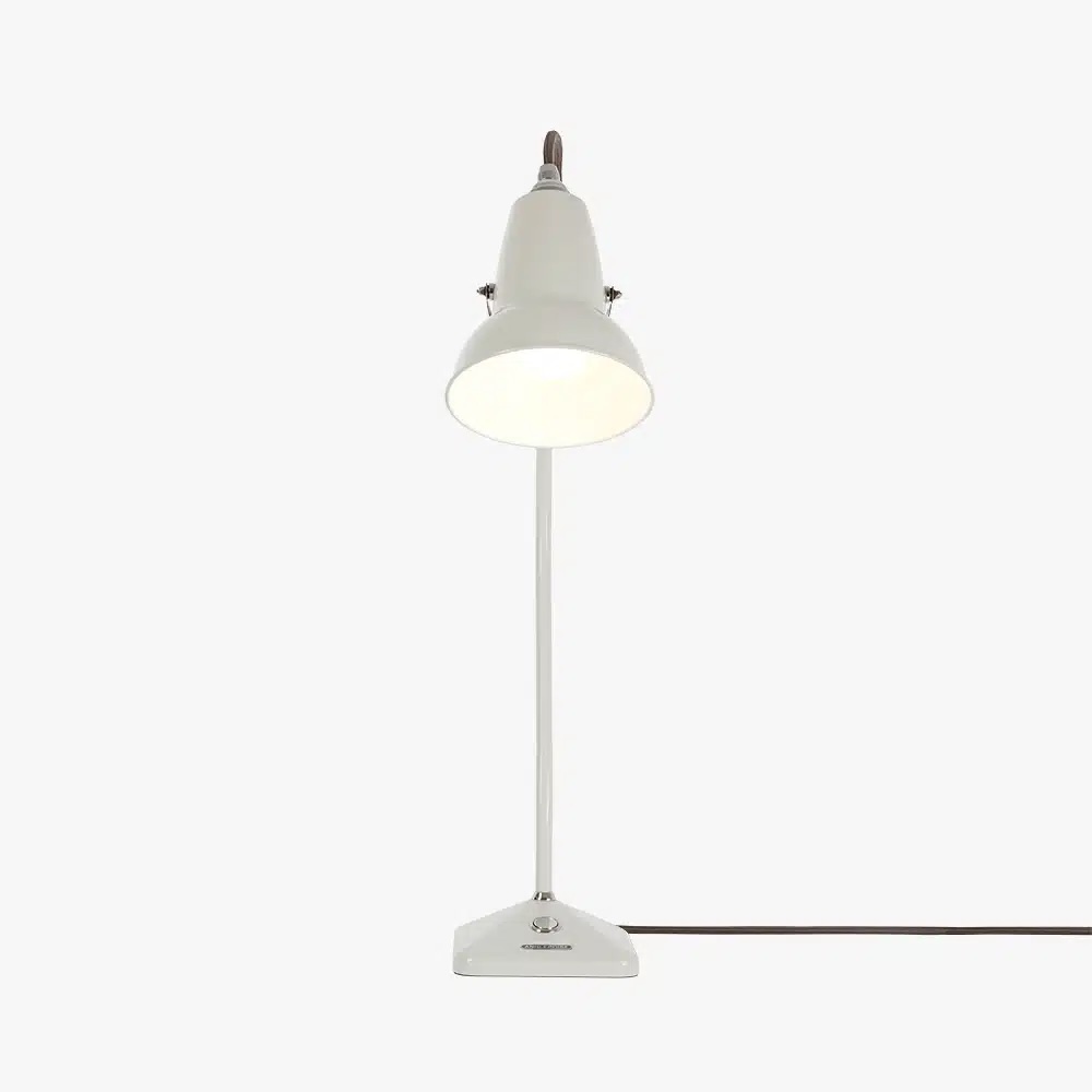 Original-1227-table-lamp-linen-white-3jpg | rewire White metal desk lamp with a rounded shade, plugged in and lit on a white surface.