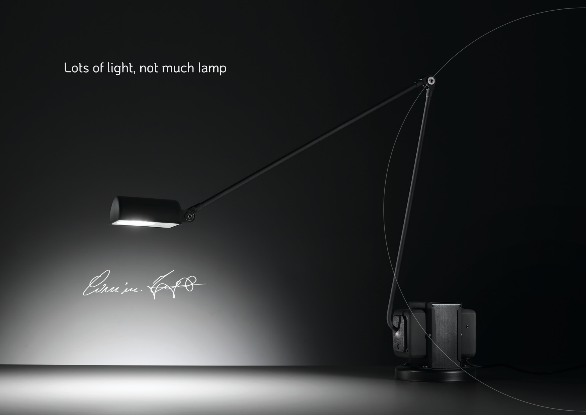Close-up of a black adjustable desk lamp with a long arm, lighting a dark surface.