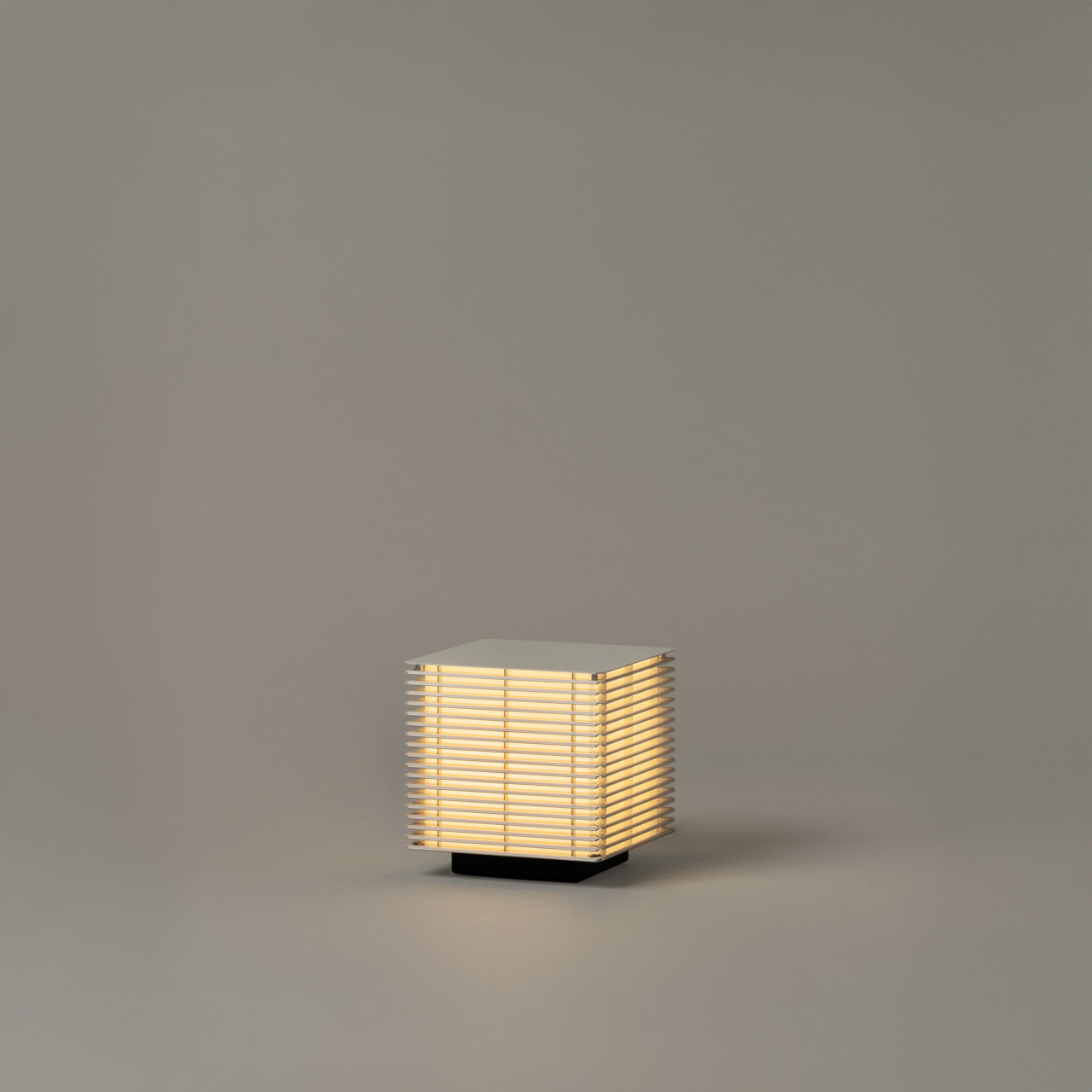 Shiro251 | rewire Small square lamp with horizontal slats glowing softly on a neutral background