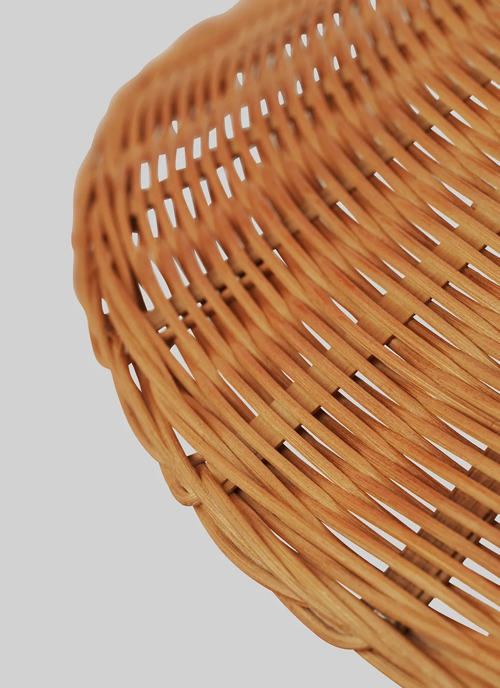 10003869_c3_9602+floor+lamp_brass_wicker+willow | rewire Close-up of a brown wicker basket showing interlaced wooden strips forming curved rows.