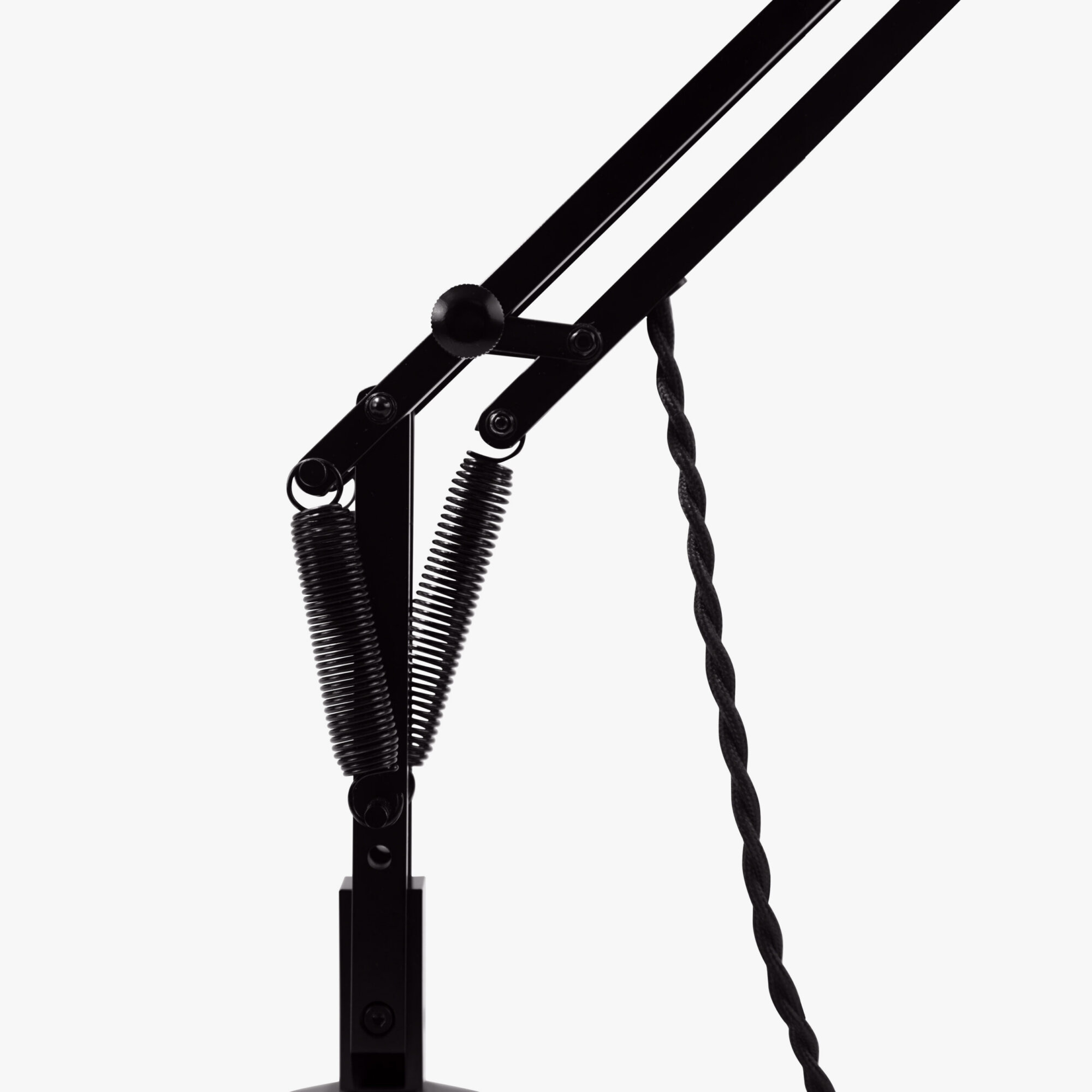 Original-315-desk-lamp-silver-black_2926ct_sq_wd1ob_3-scaled | rewire Close-up of a black metal adjustable lamp arm with coiled springs and a twisted cord heightening the zigzag contact point.