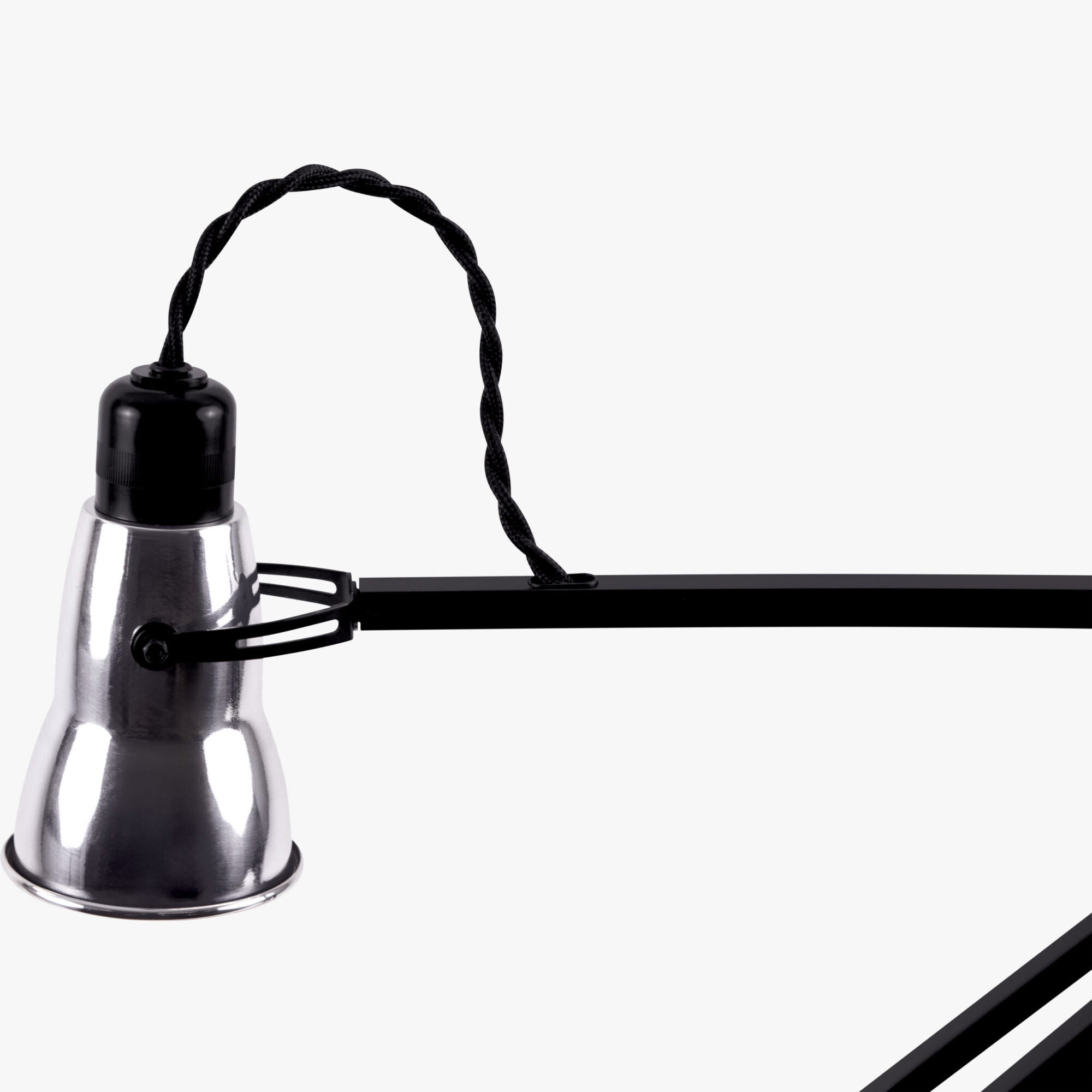 Original-315-desk-lamp-silver-black_2926ct_sq_ws4ob_-scaled | rewire Close-up of a metal lamp base with a black braided cord looping above it on a light background.