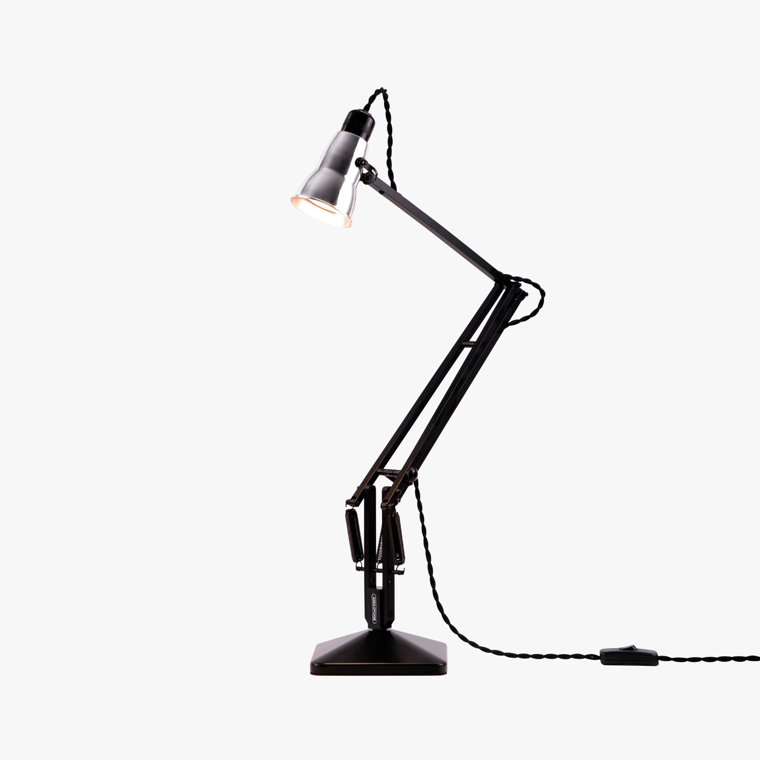 Original-315-desk-lamp-silver-black_2926ct_sq_wt1ob2_ | rewire Black adjustable desk lamp with a metal shade, extended arm, and a cord trailing to the right (lit). It sits on a square base.
